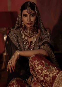 Black and Maroon Pakistani Bridal Dress With Heavy Gold Embroidery Seated View by Zeeniya